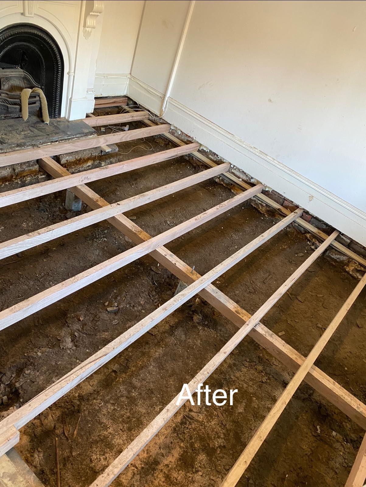 A room with a wooden floor and a fireplace.