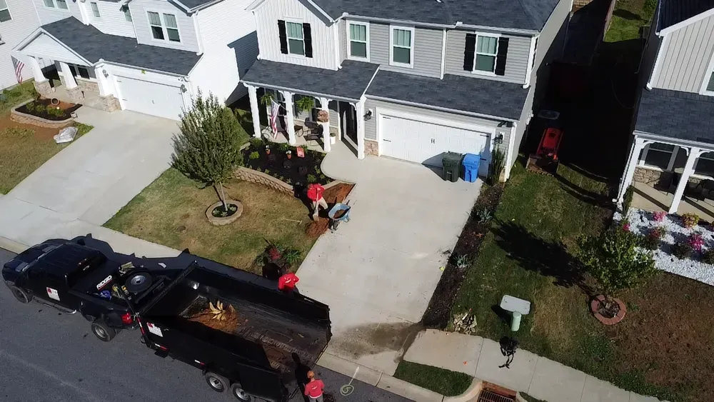 An aerial view of a house with a dumpster in front of it.