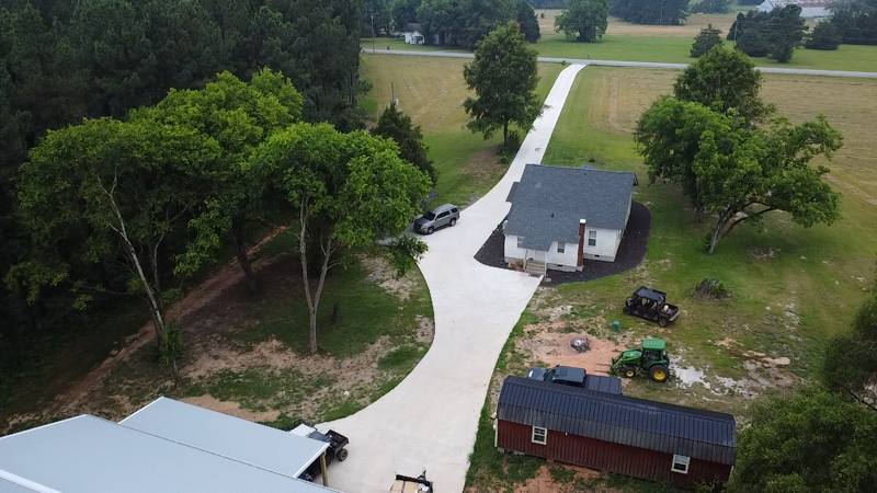 A concrete driveway with trees in the background is being built.