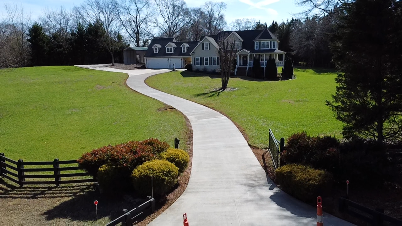 A concrete walkway is being built in front of a house.
