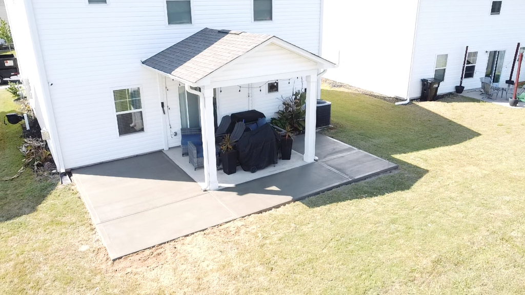 An aerial view of a house with a dumpster in front of it.