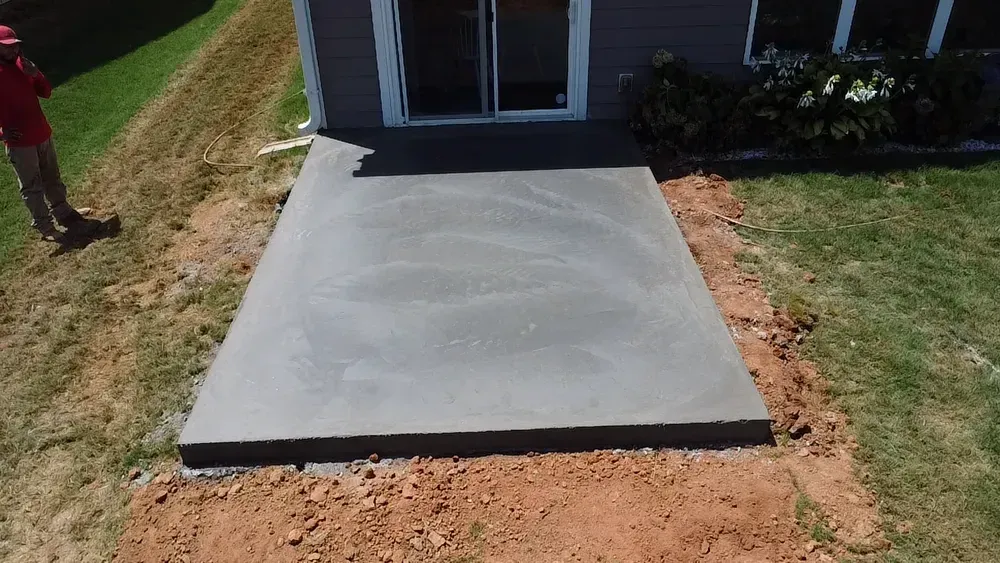 A concrete walkway is being built in front of a house.