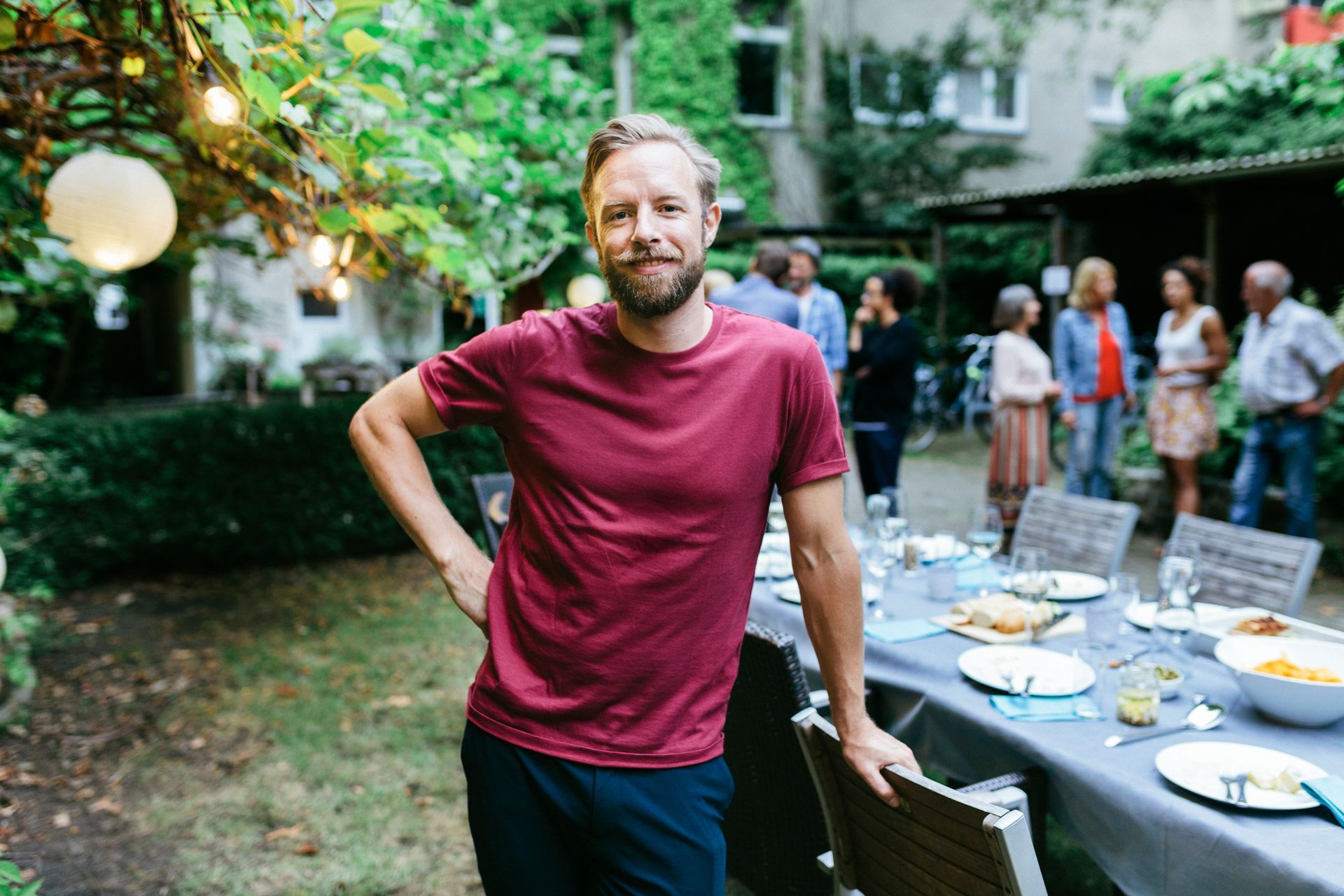 A man is standing in front of a table with plates on it.