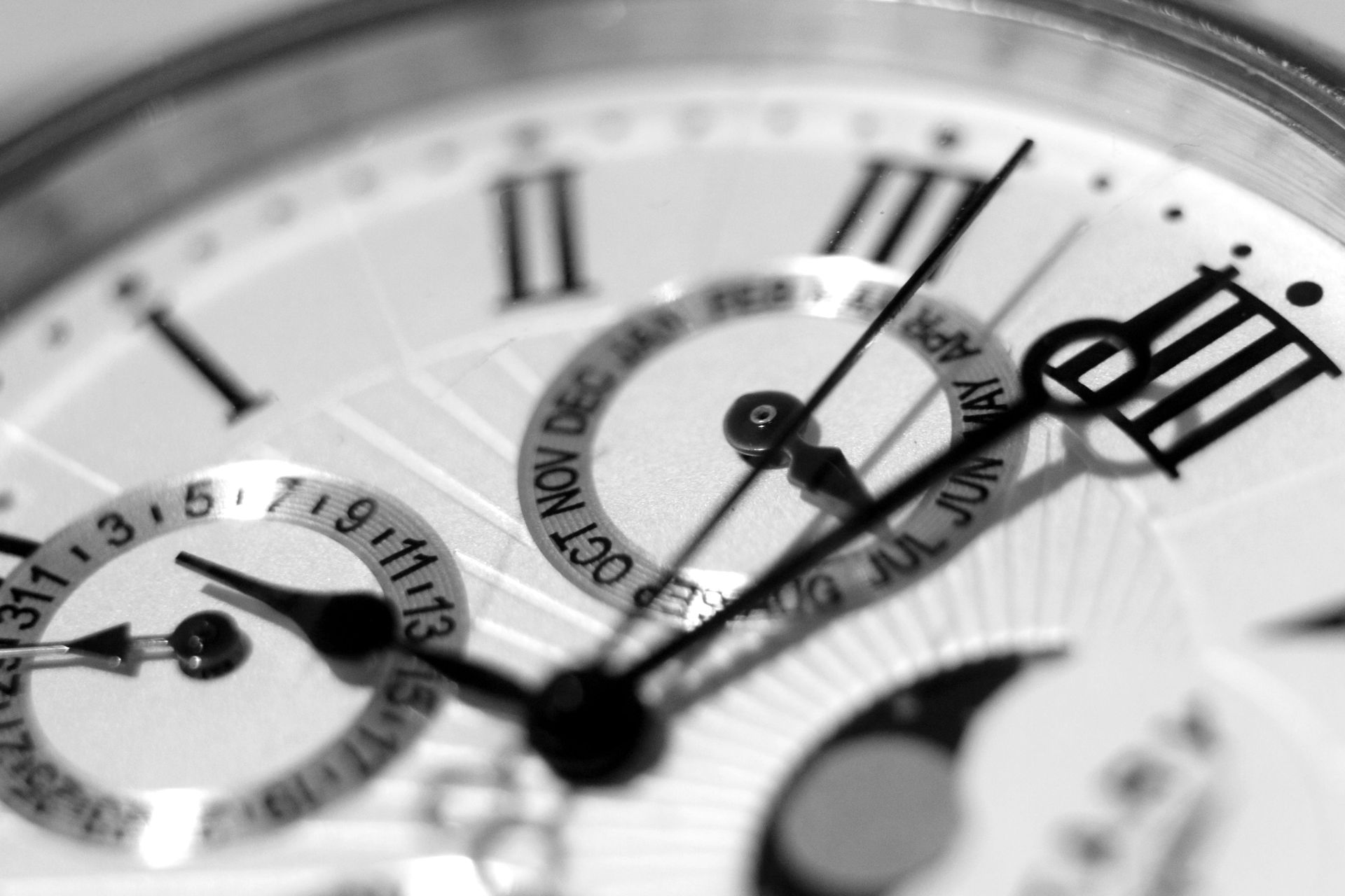 A black and white photo of a watch face with roman numerals