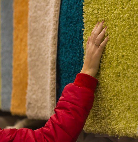 Woman spends shopping and selects plush carpets by hand in the store