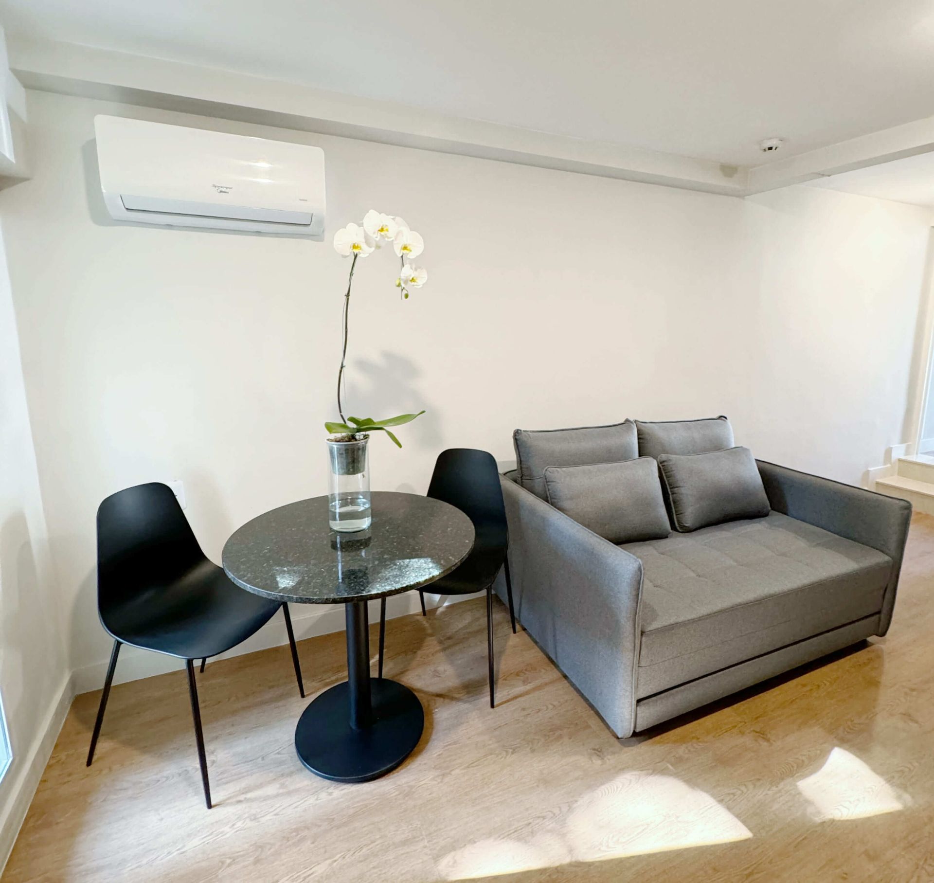 Uma sala de estar com um sofá, uma mesa e cadeiras