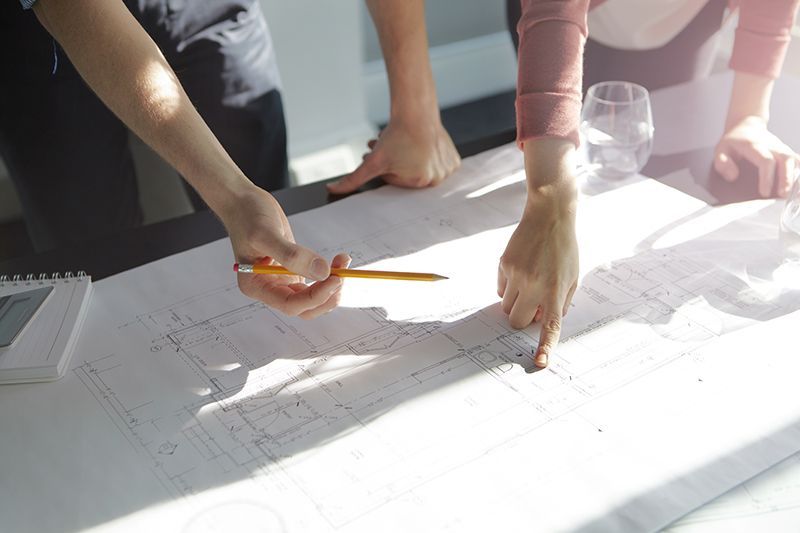 Un gruppo di persone sta osservando un progetto su un tavolo.