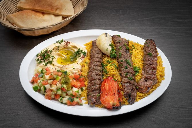 Beef Kofta Plate A white plate topped with a wrap and a skewer of meat.