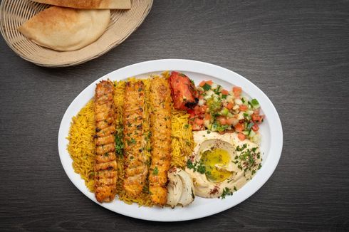 Chicken Kofta Plate A plate of food with rice , meat and vegetables on a table.