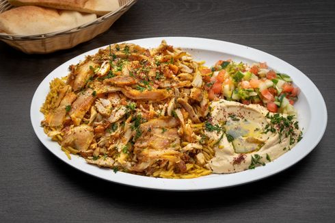 Chicken Shawarma Plate A white plate topped with chicken , hummus , and rice.