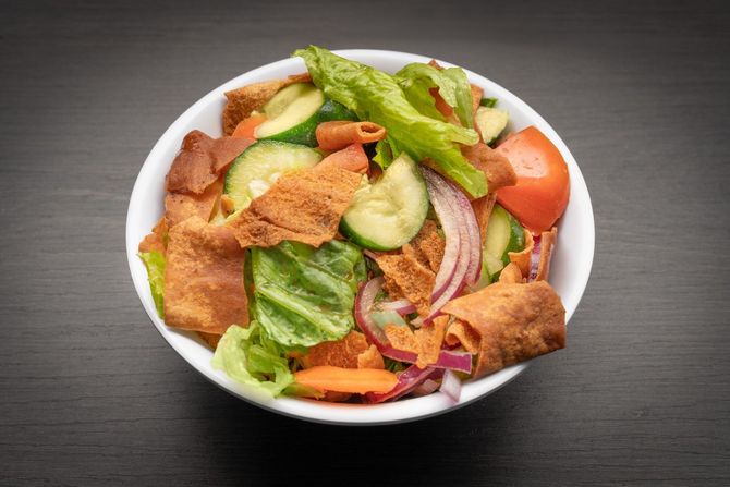 Fattoush Salad A close up of a salad in a bowl on a table.