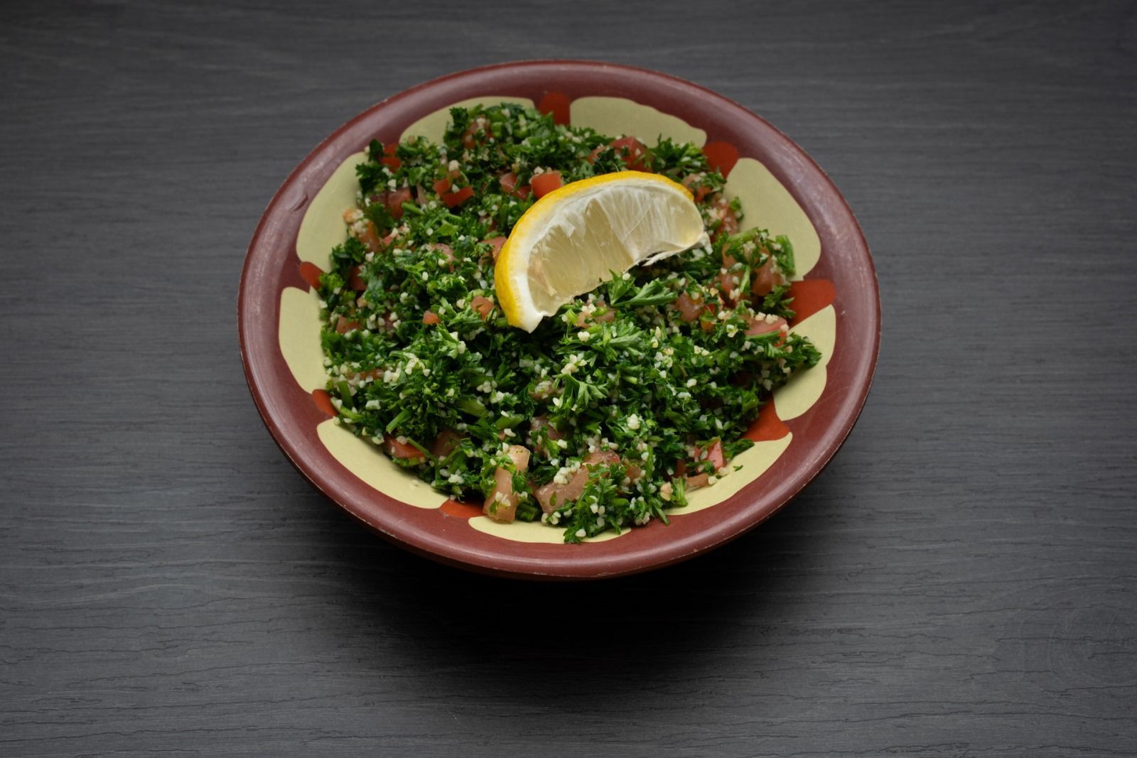 A bowl of food with a slice of lemon on top.