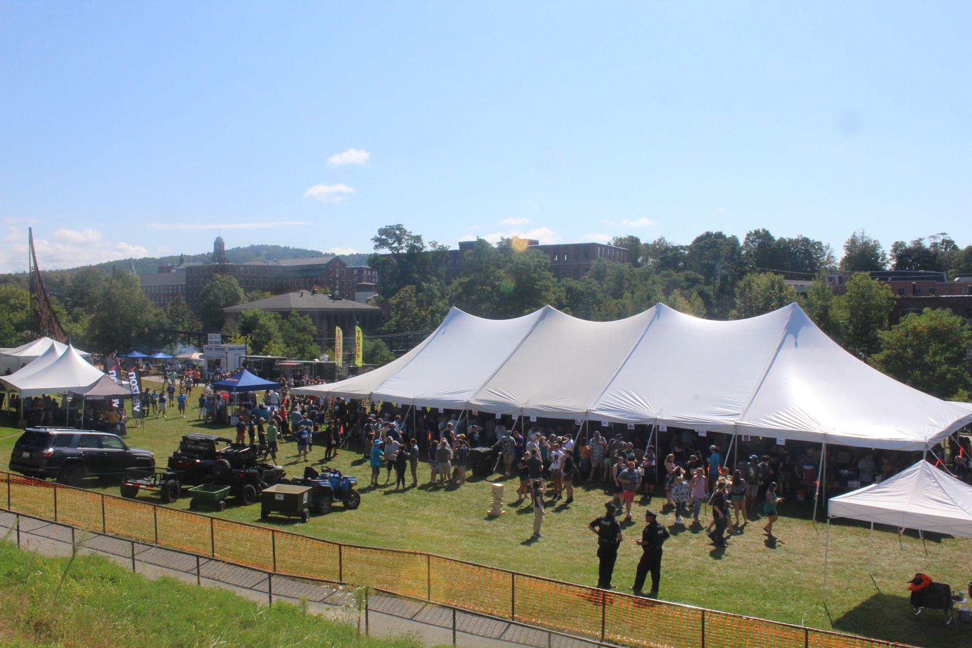 A large white tent is in the middle of a grassy field