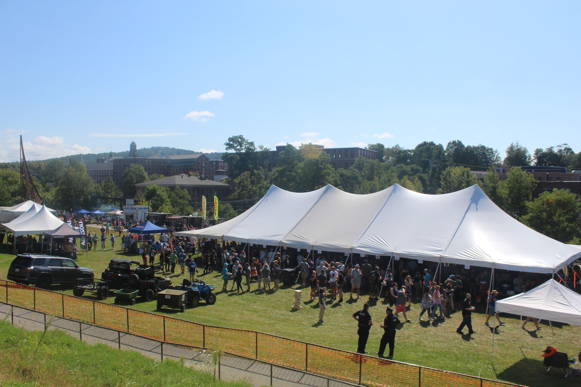 A large white tent is in the middle of a grassy field