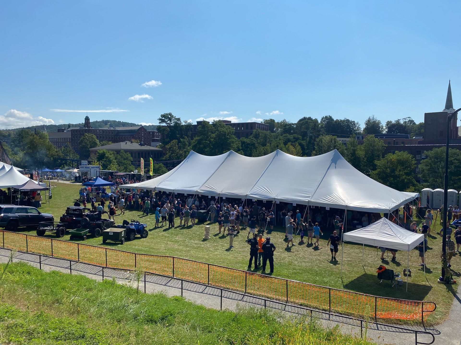 A large white tent is sitting in the middle of a grassy field.