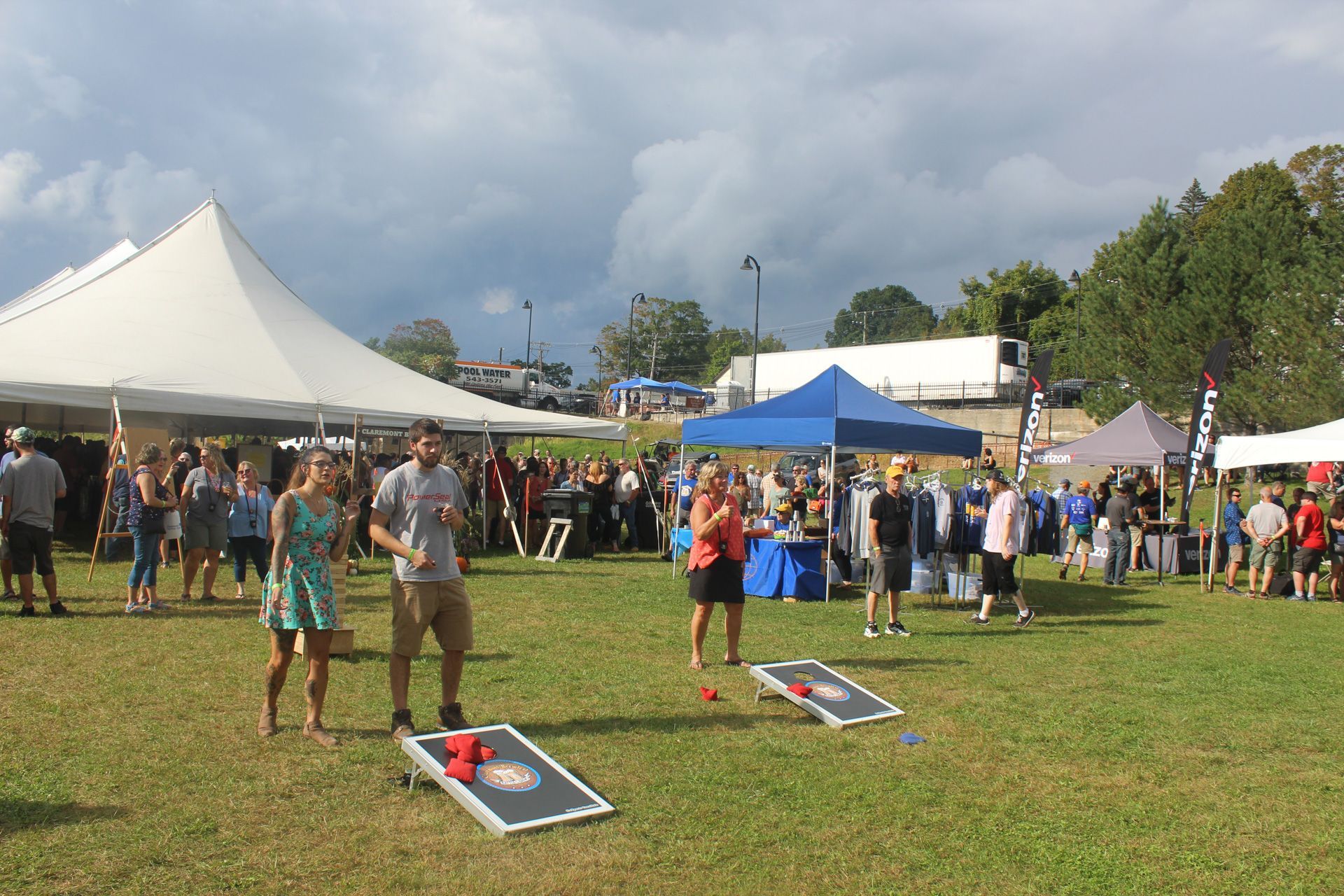 A group of people are playing cornhole in a field.