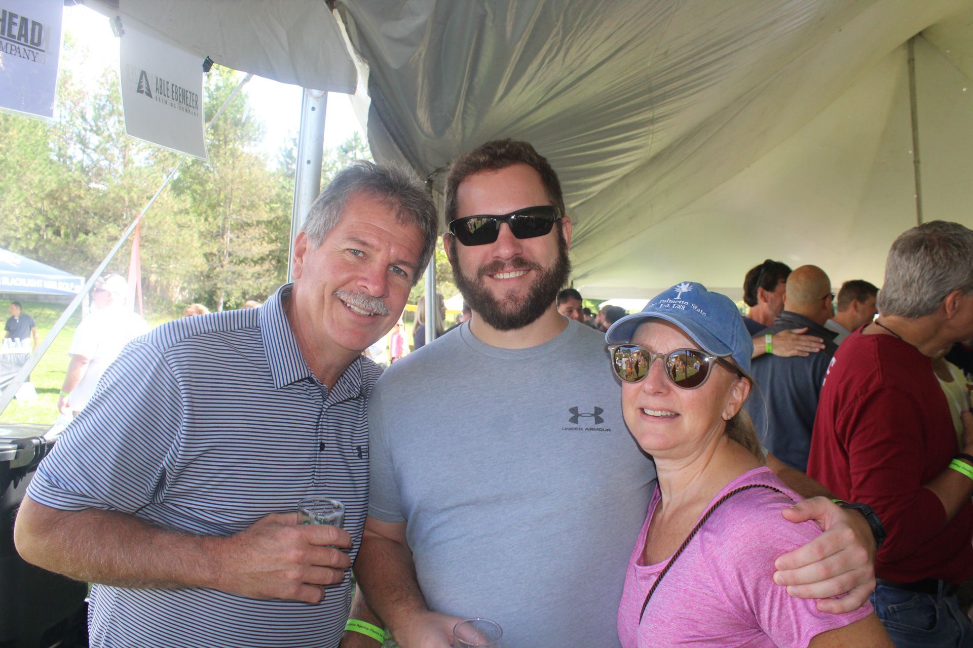 A group of people are posing for a picture under a tent.