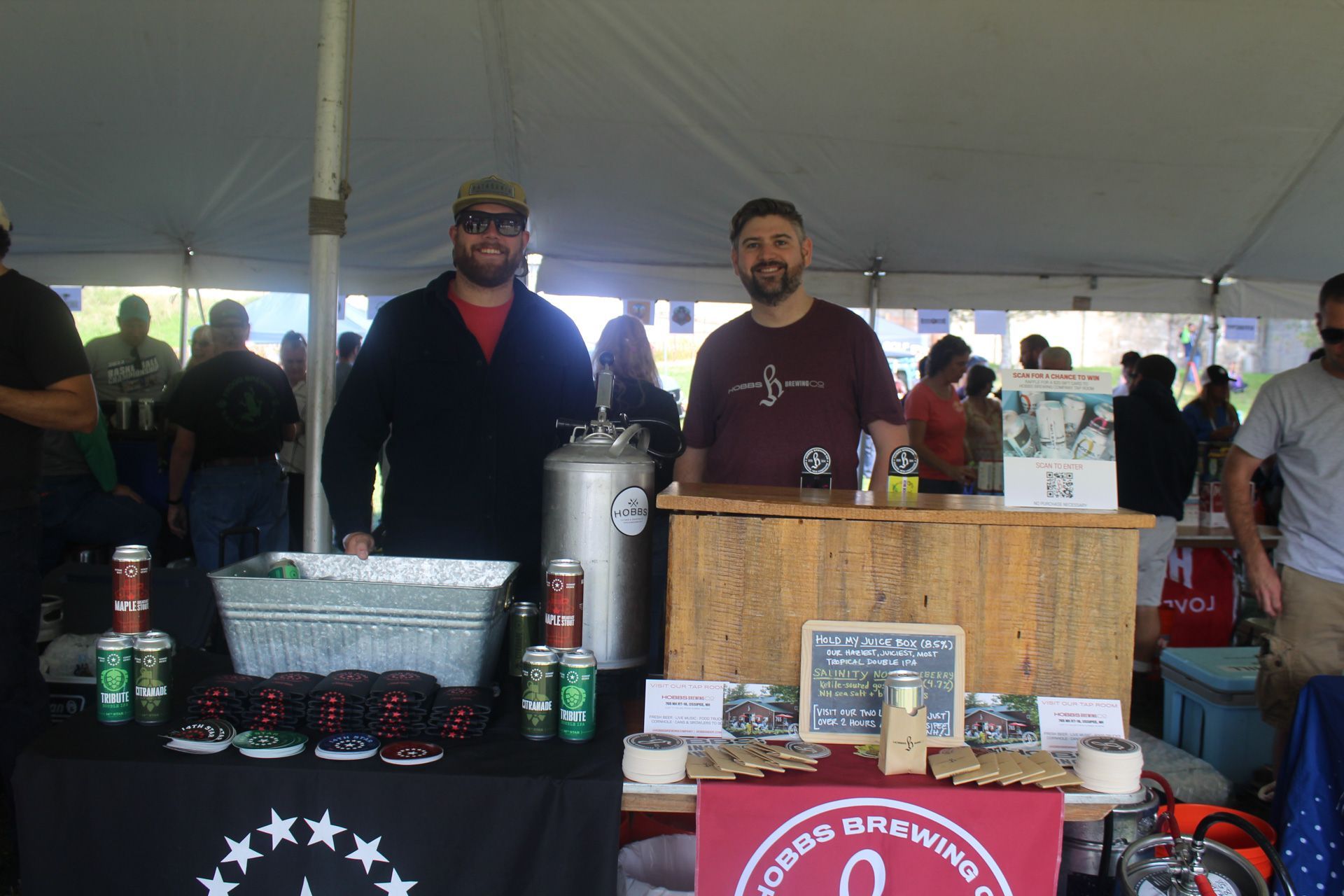 Two men are standing in front of a table with a sign that says ' a ' on it.