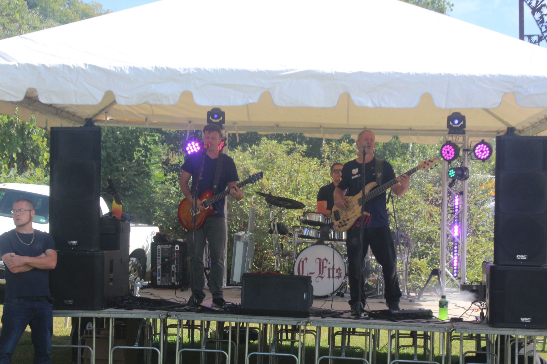 A band is playing on a stage under a tent.