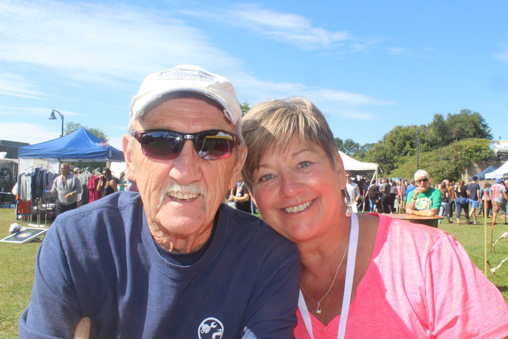 A man and a woman are posing for a picture in a field.