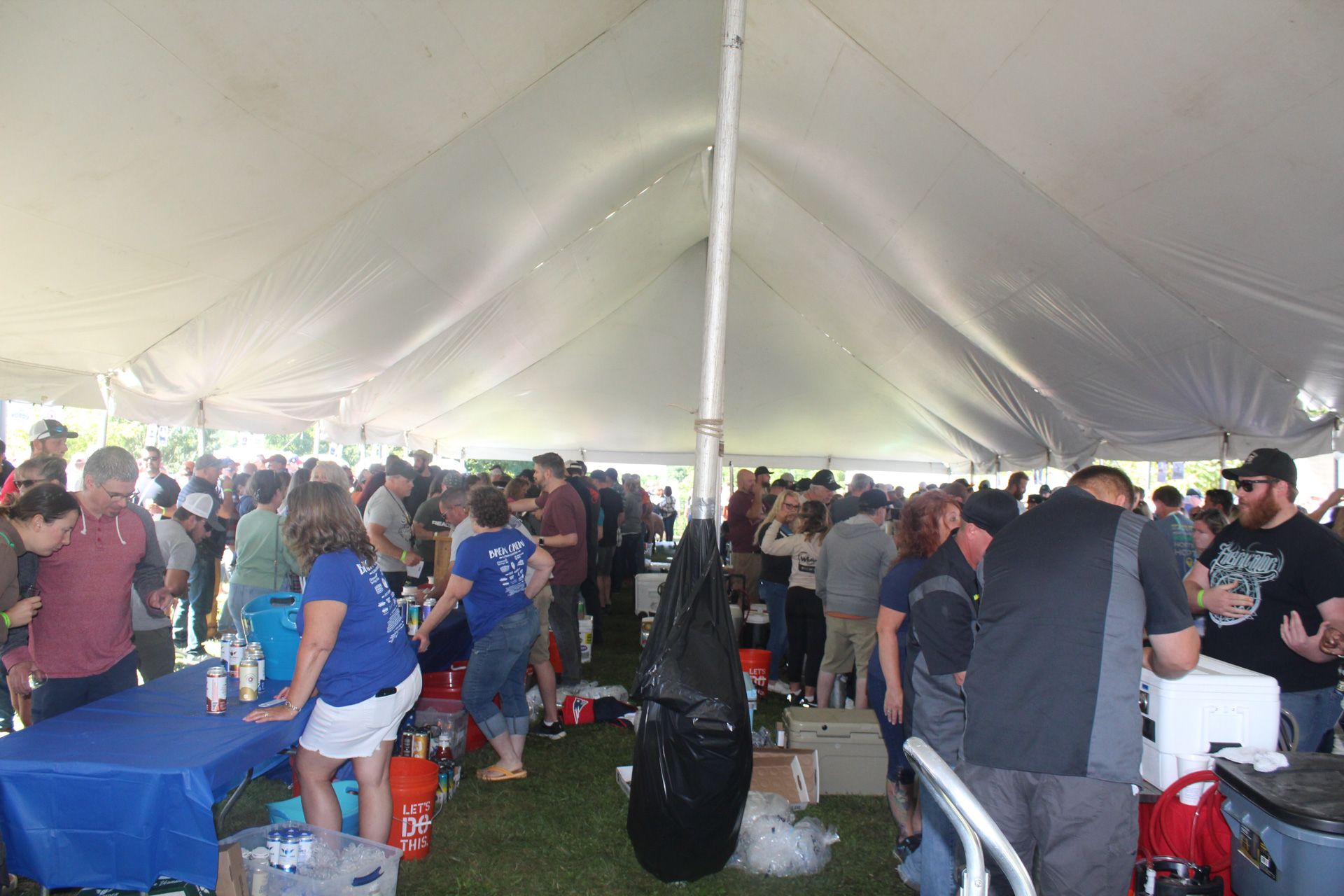 A large group of people are gathered under a tent.