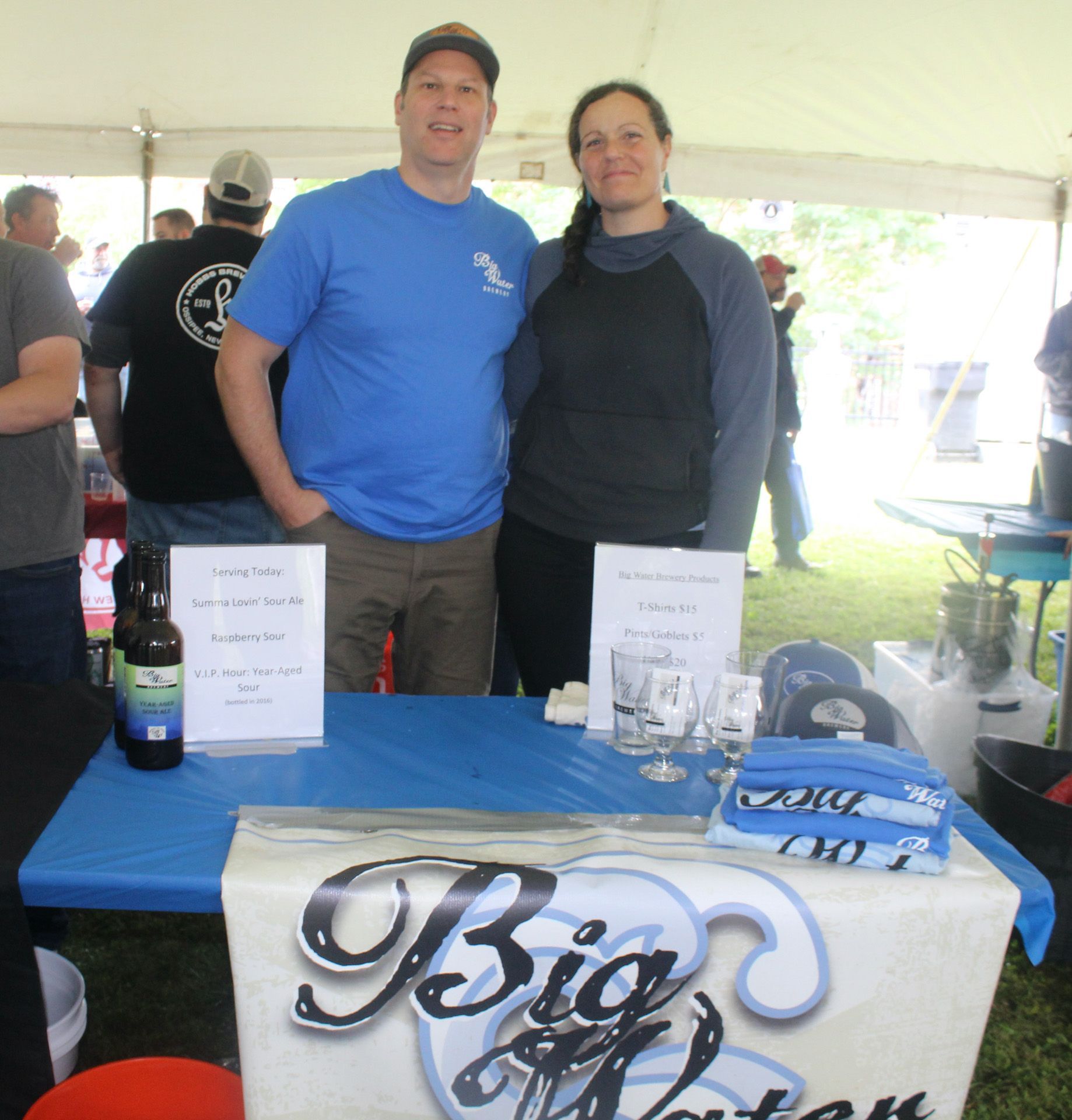 Two people standing in front of a table that says big