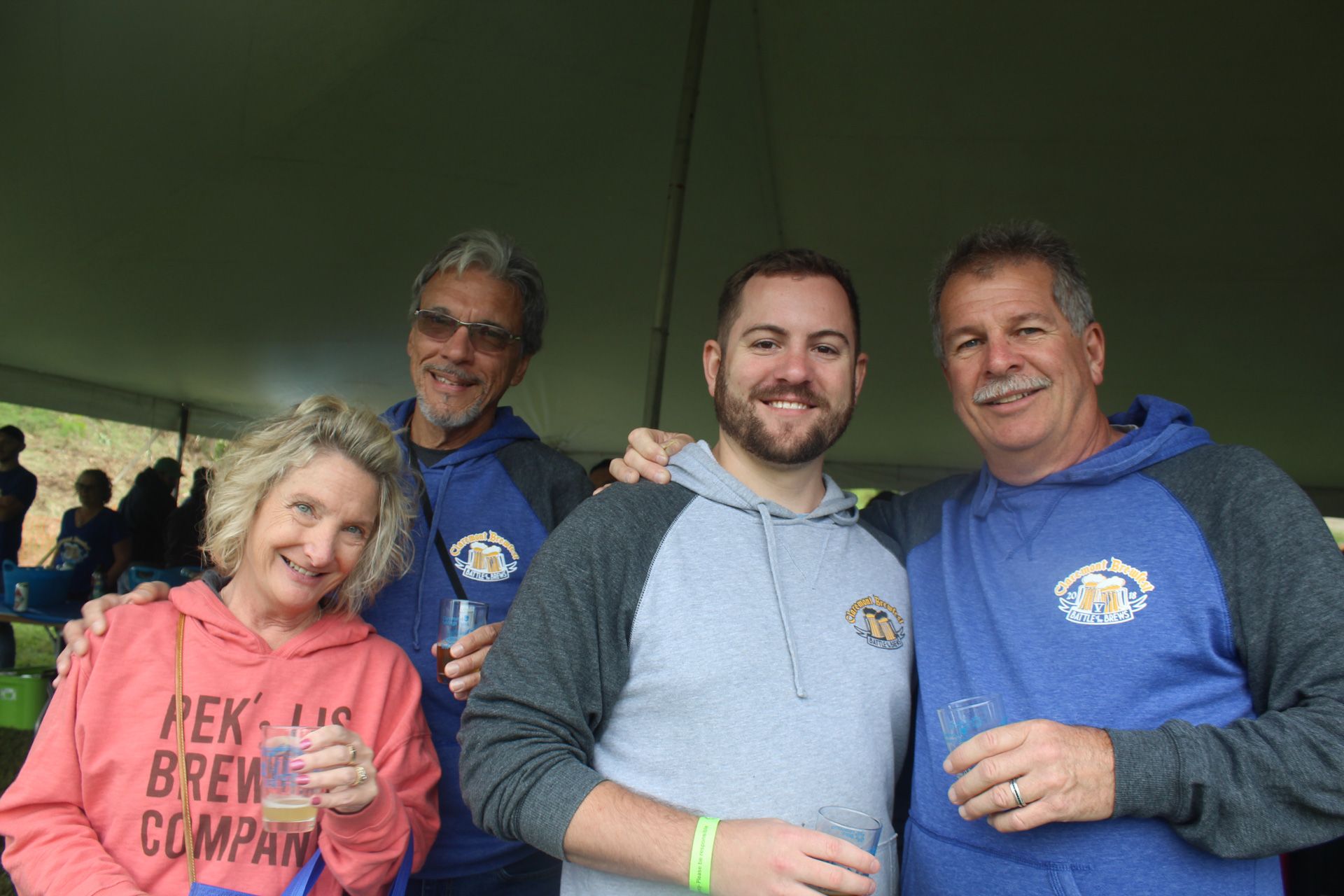 A group of people are posing for a picture under a tent.