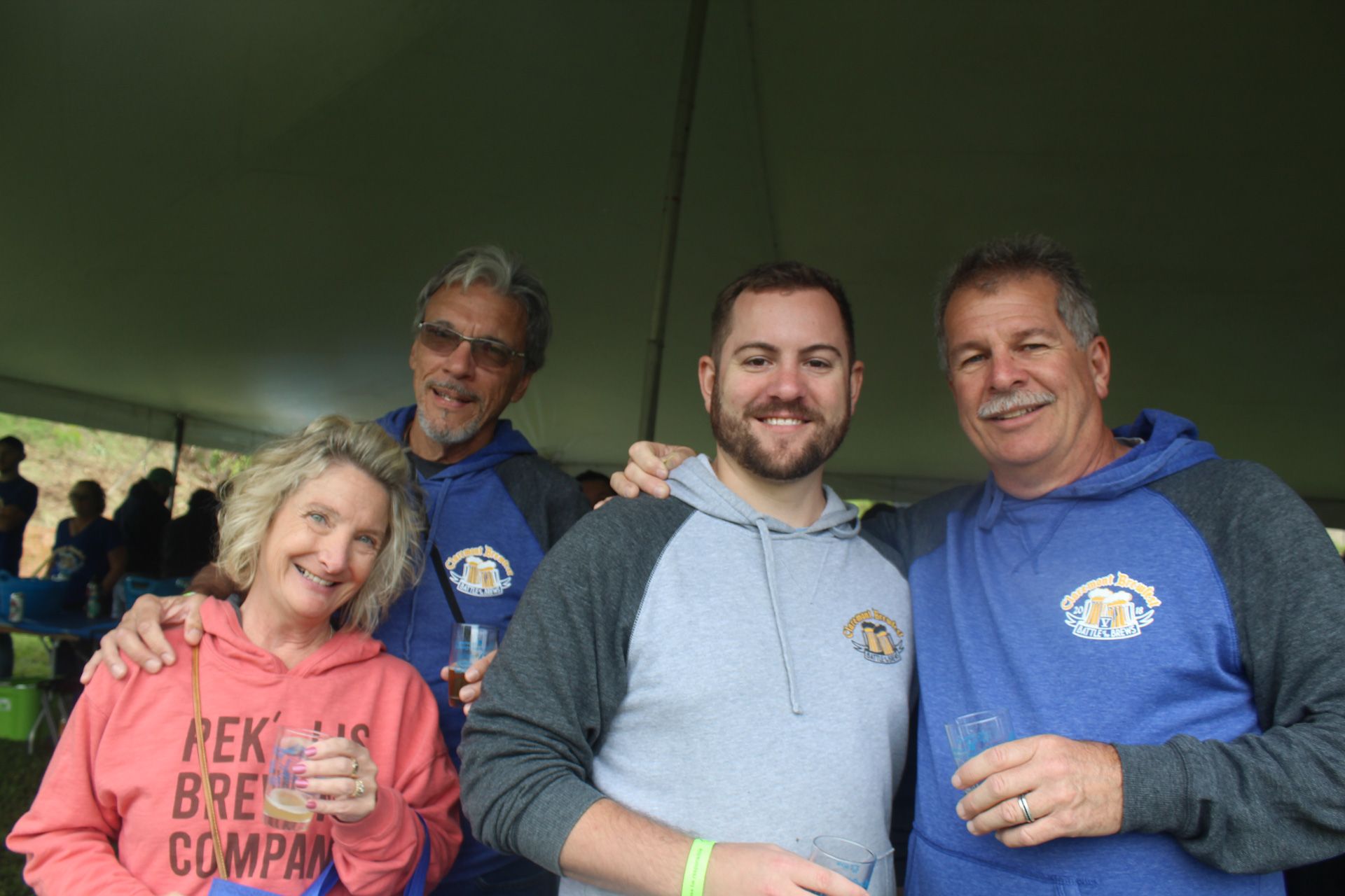 A group of people are posing for a picture under a tent.