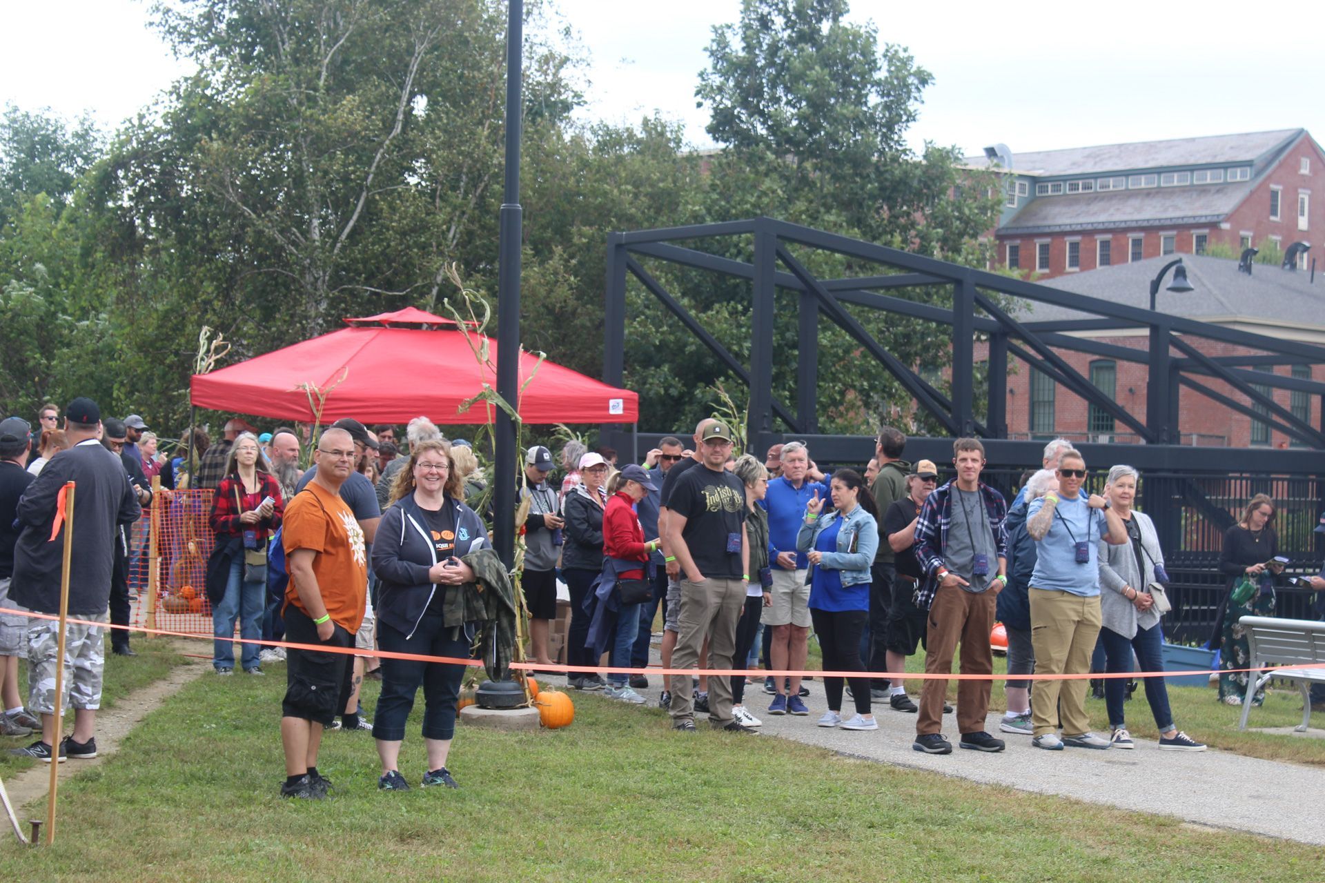 A group of people are standing in a line in a park.