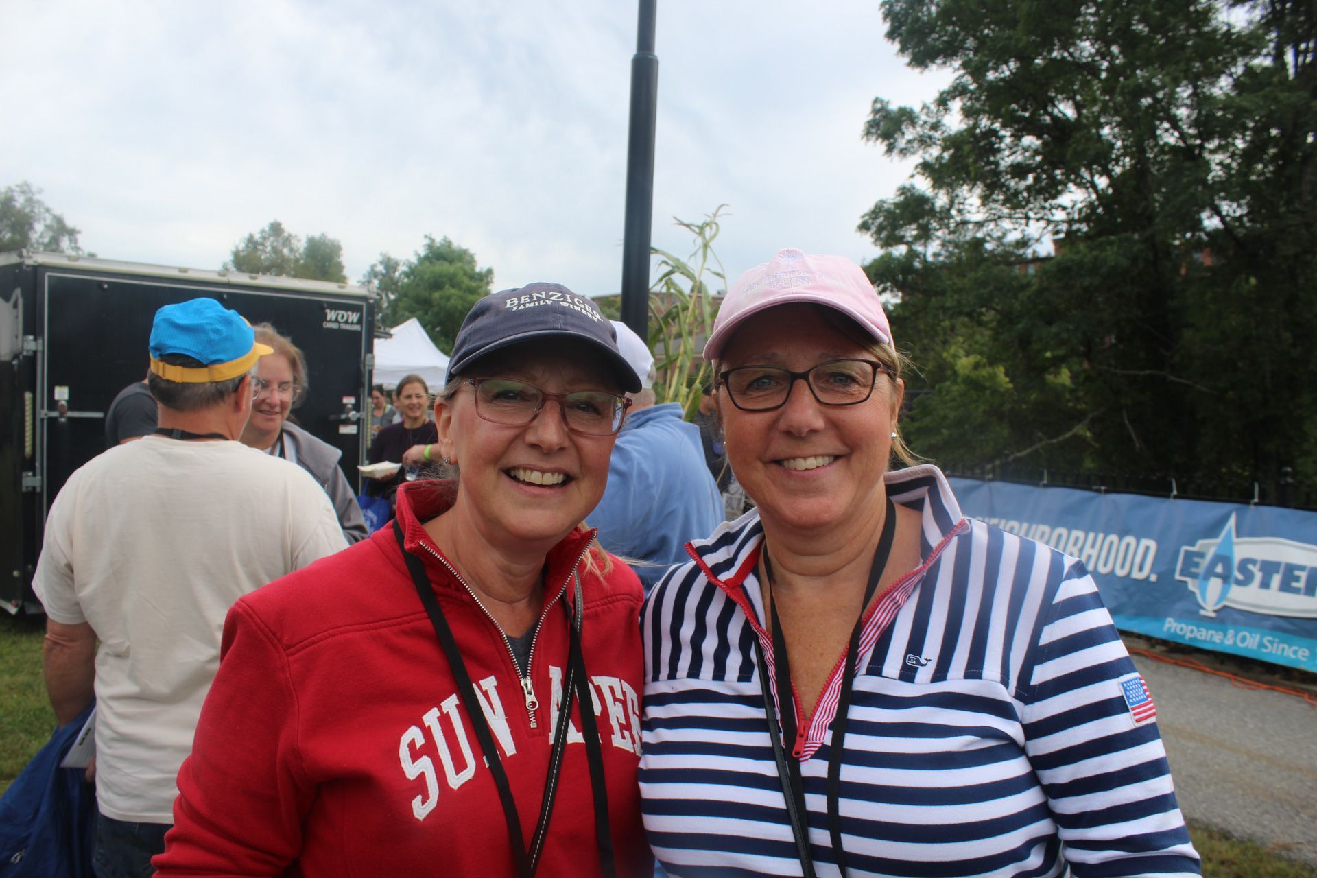 Two women are posing for a picture in front of a blue banner that says easter