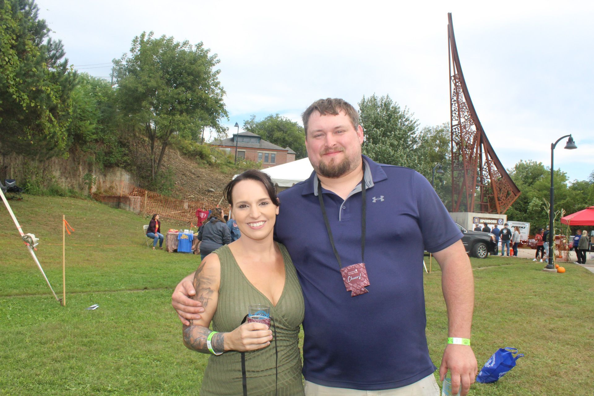 A man and a woman are posing for a picture in a park.