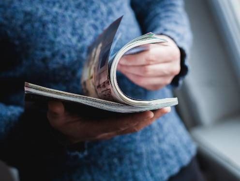 Una persona sta leggendo un libro tenendo le mani sulle pagine.