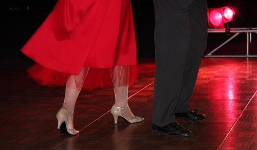 A man and a woman are dancing on a dance floor.