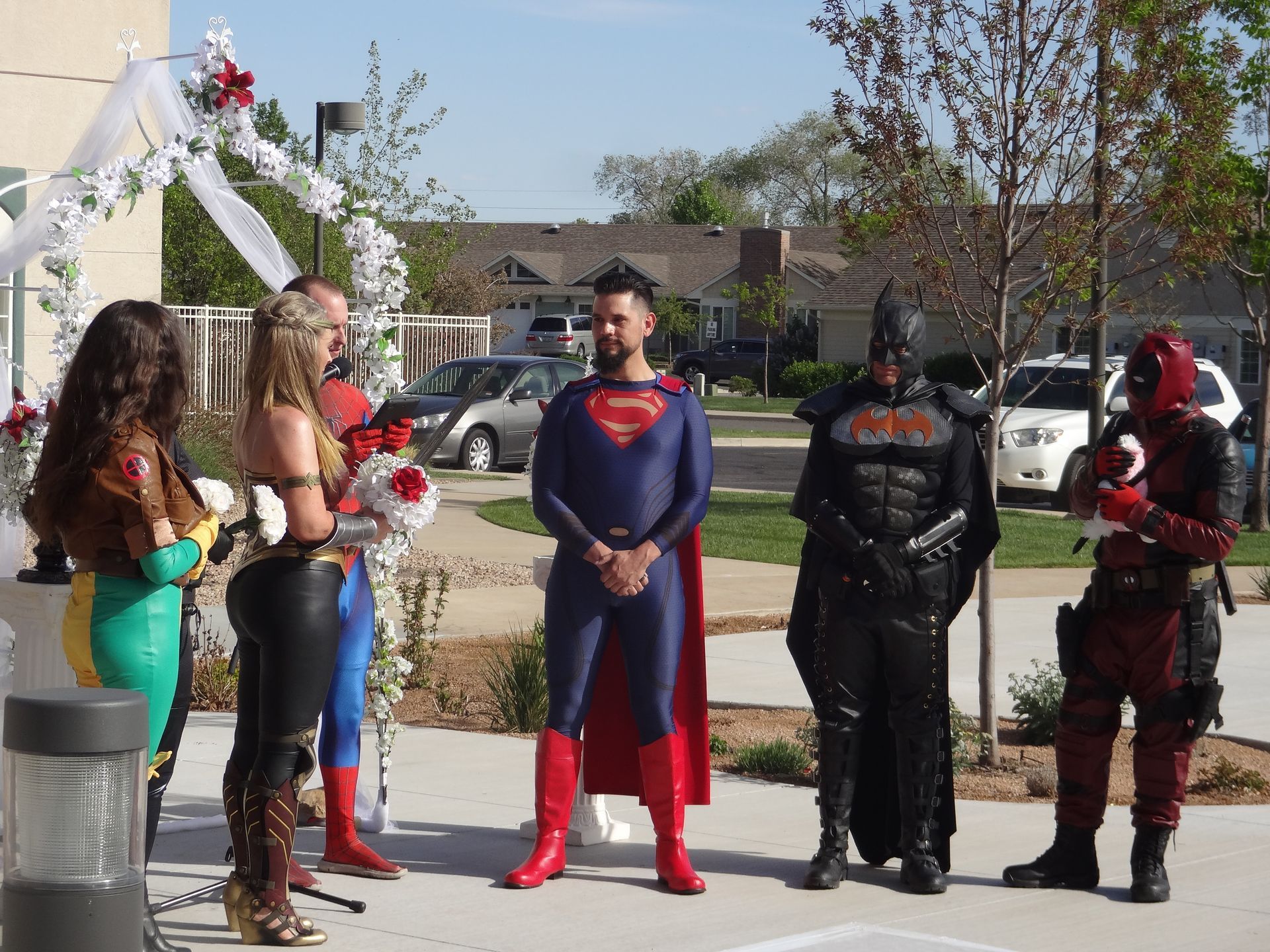 A group of people dressed in superhero costumes are standing in a line
