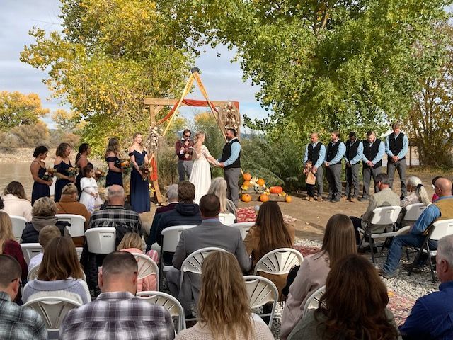 A group of people are sitting in chairs watching a wedding ceremony.