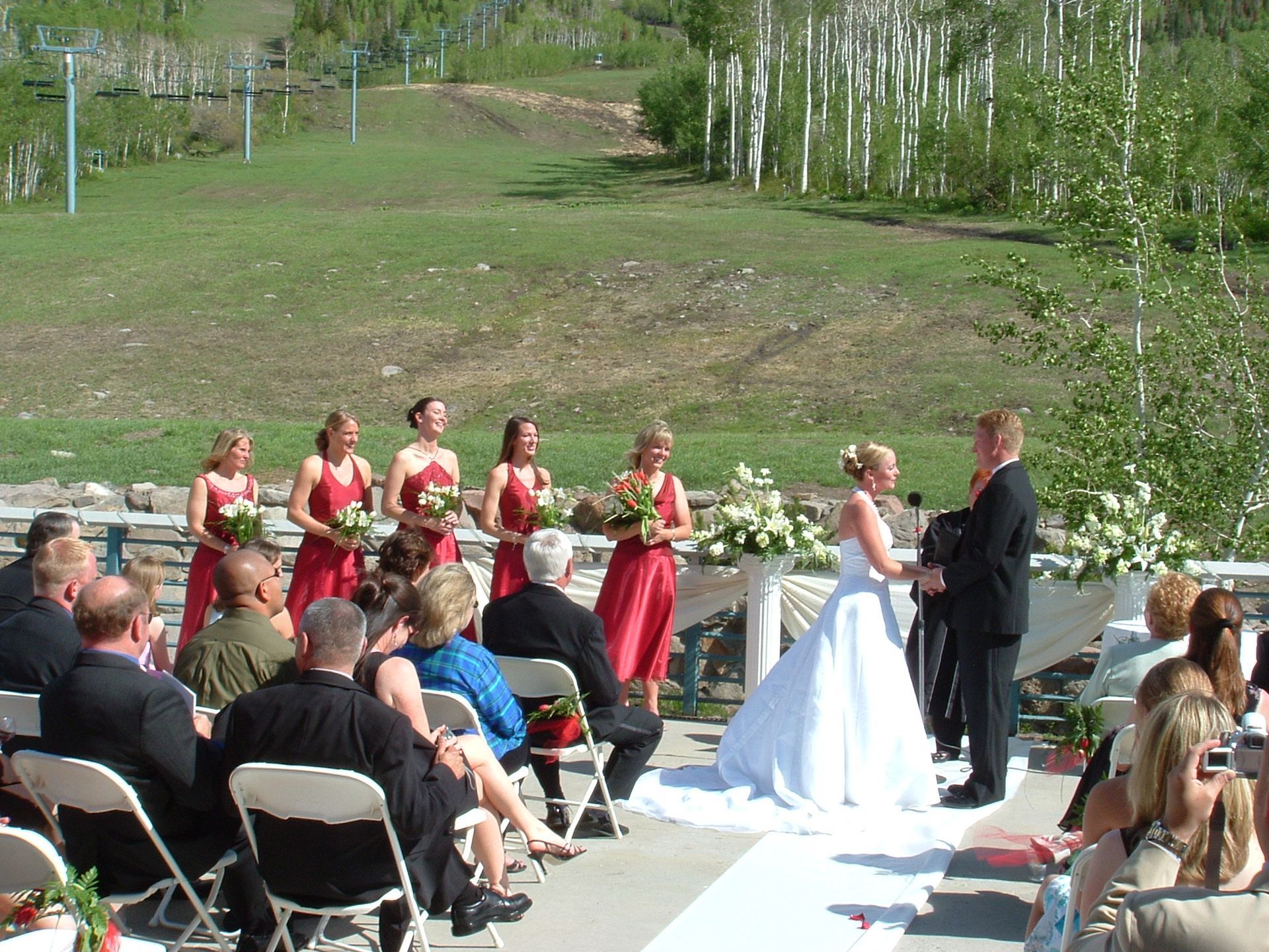 A bride and groom are getting married in front of a crowd of people