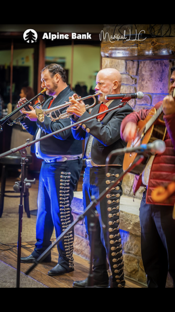 A group of men are playing instruments in front of a sign that says alpine bank