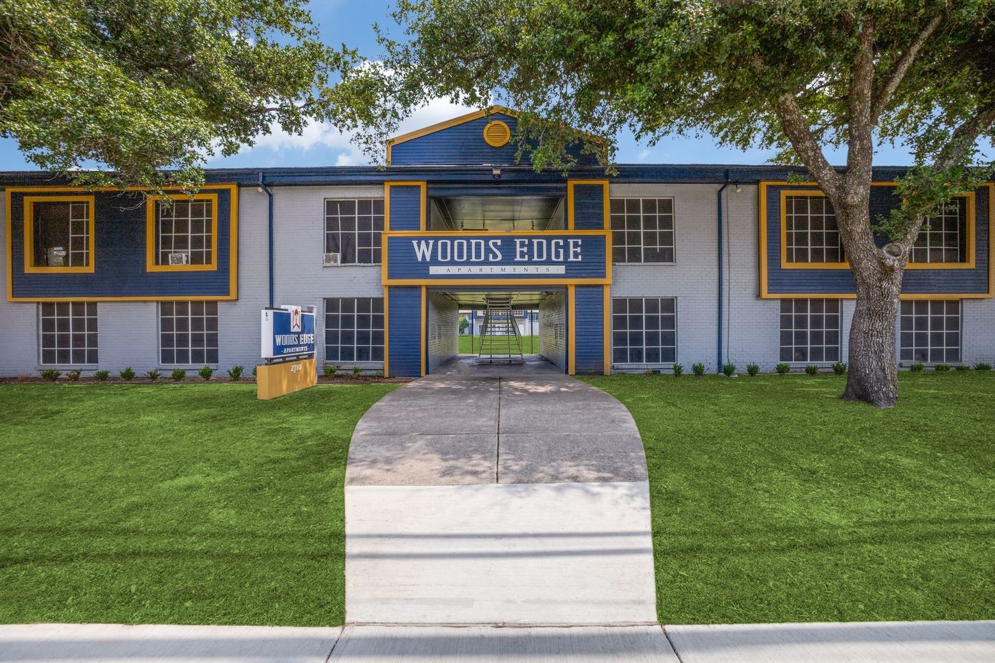 A large blue and white building with a tree in front of it.