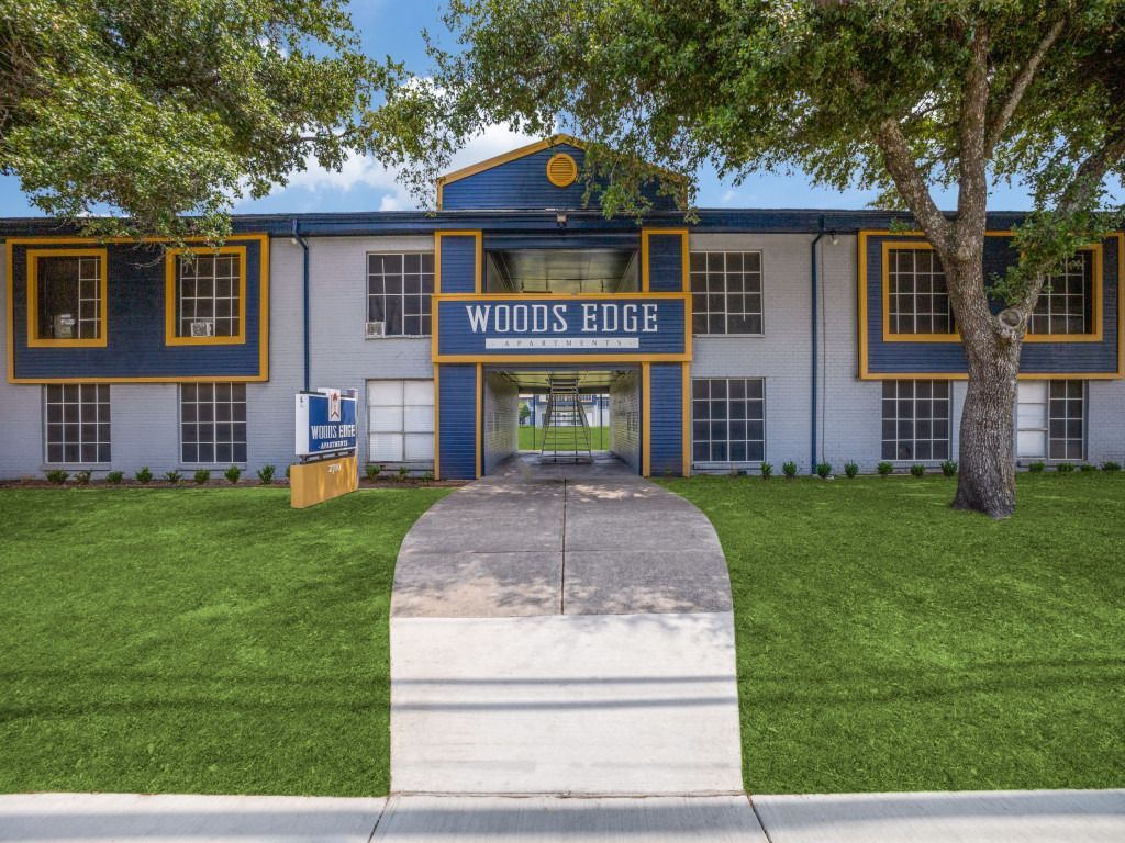 A large building with a blue and yellow sign that says woods edge