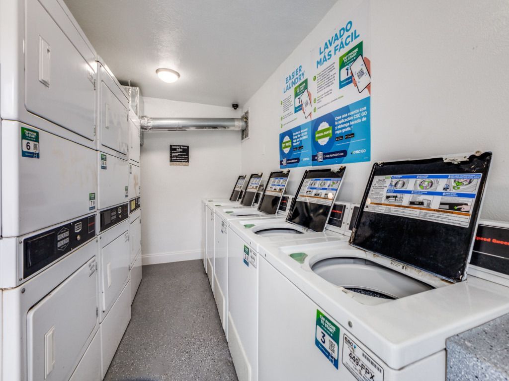 A laundromat with a lot of washing machines and dryers.