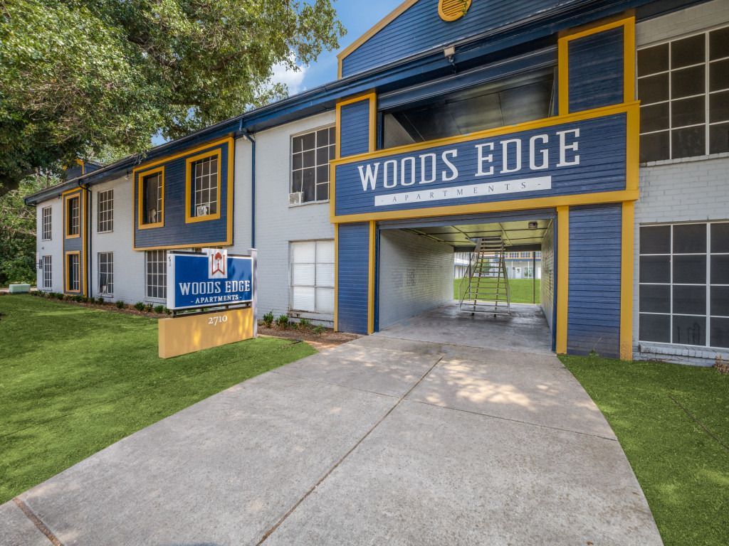 A blue and yellow building with a sign that says woods edge