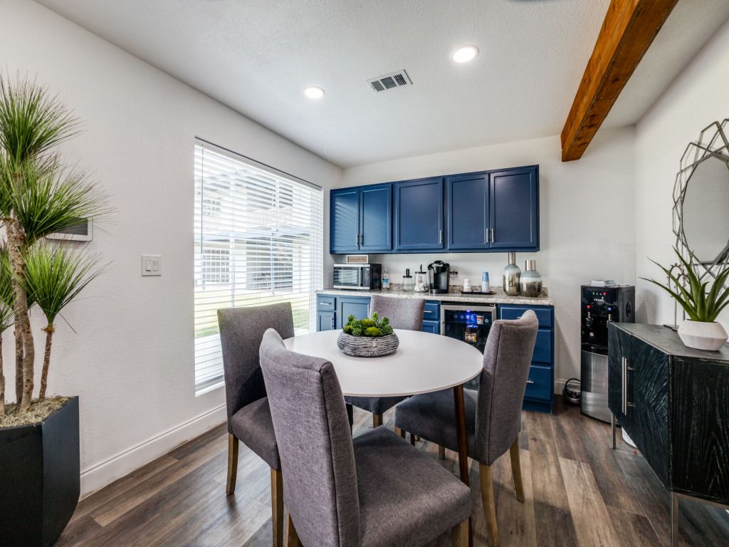 A dining room with a table and chairs and blue cabinets.