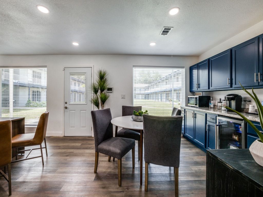 A kitchen with blue cabinets and a table and chairs in it.