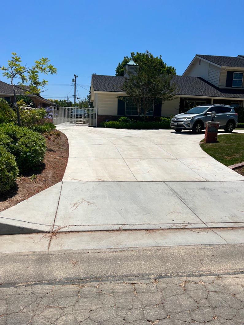 A car is parked in the driveway of a house.
