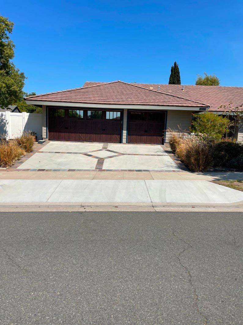 A house with a large garage door and a driveway leading to it.