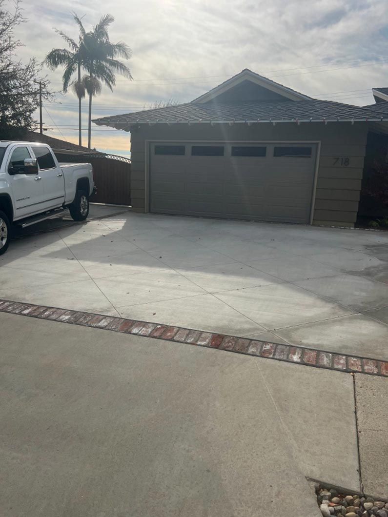 A white truck is parked in front of a garage.