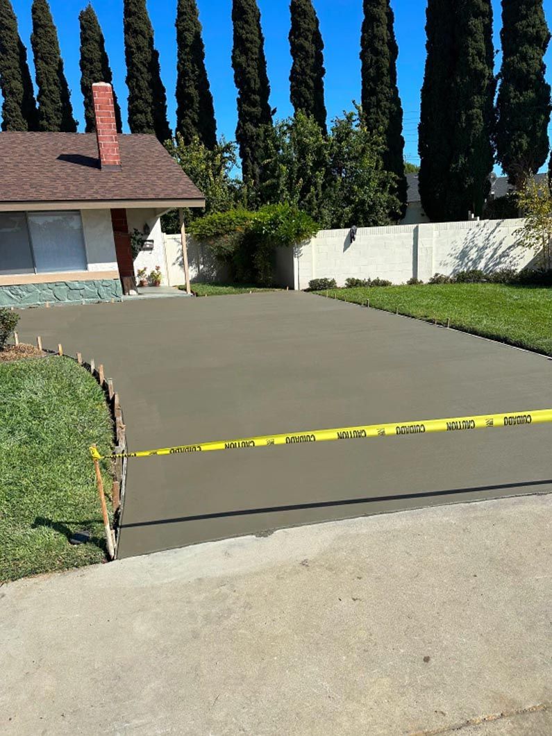 A concrete driveway is being built in front of a house.