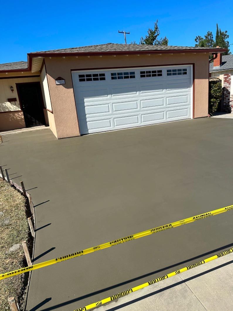 A concrete driveway is being built in front of a house.