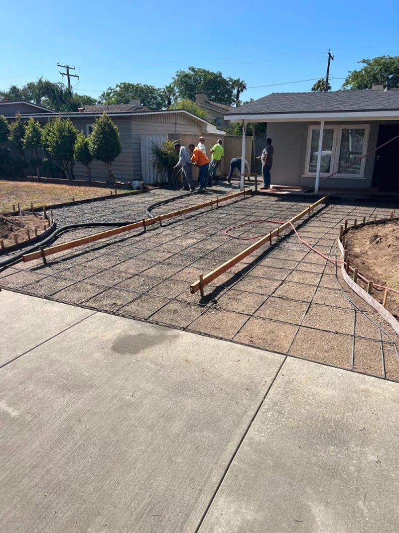 A concrete driveway is being built in front of a house.
