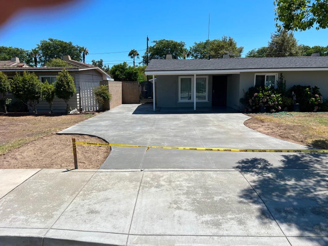 There is a concrete driveway in front of a house.